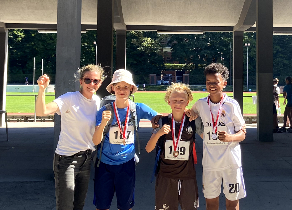 Schüler mit Medaillen und ihre Lehrerin