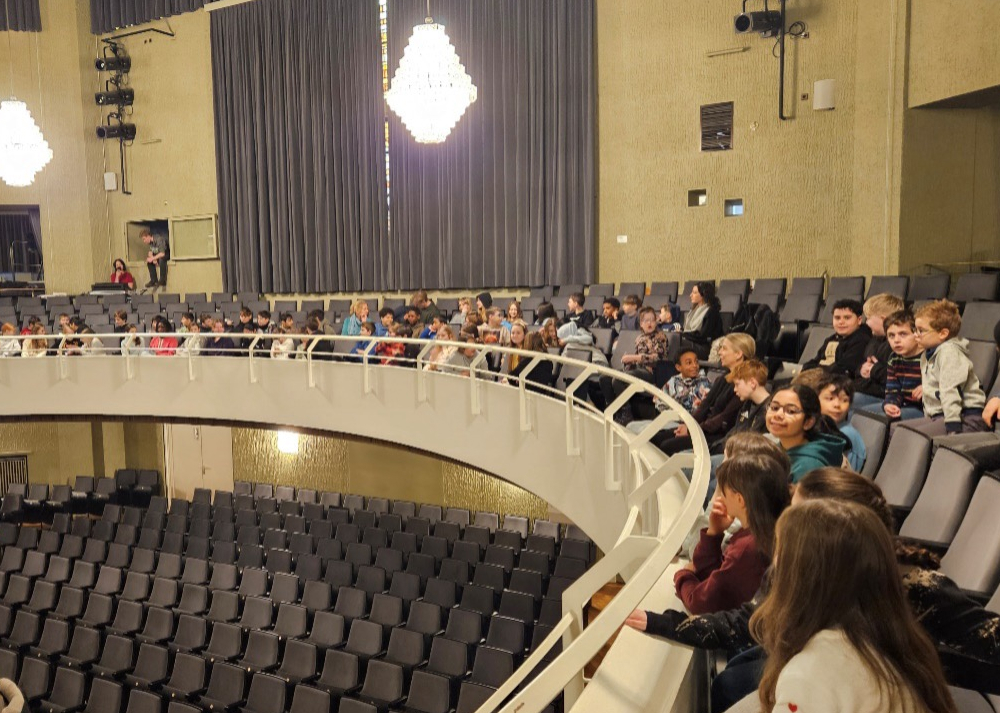 Schüler:innen sitzen im Theater