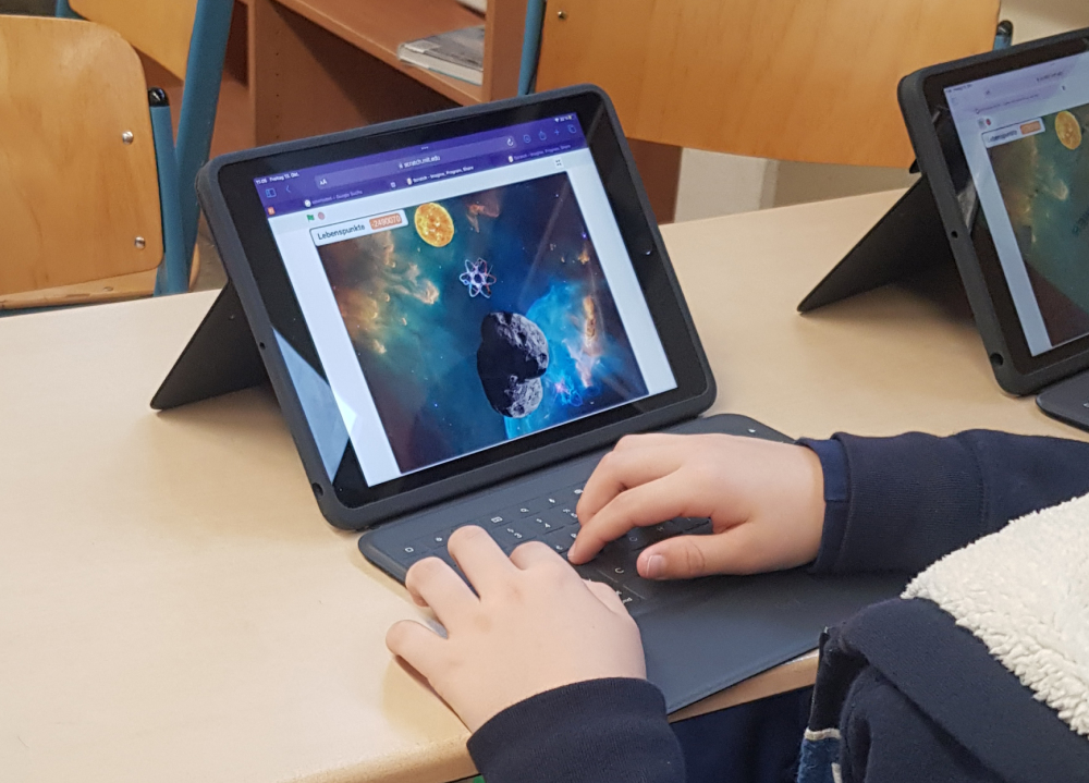 Schüler programmiert Spiel am Laptop