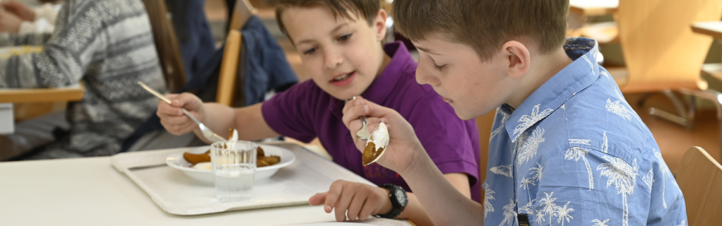 Zwei Kinder beim Essen in der Mensa