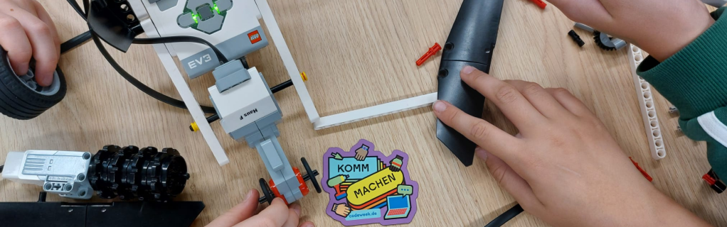 Schüler:innenhände mit Roboter