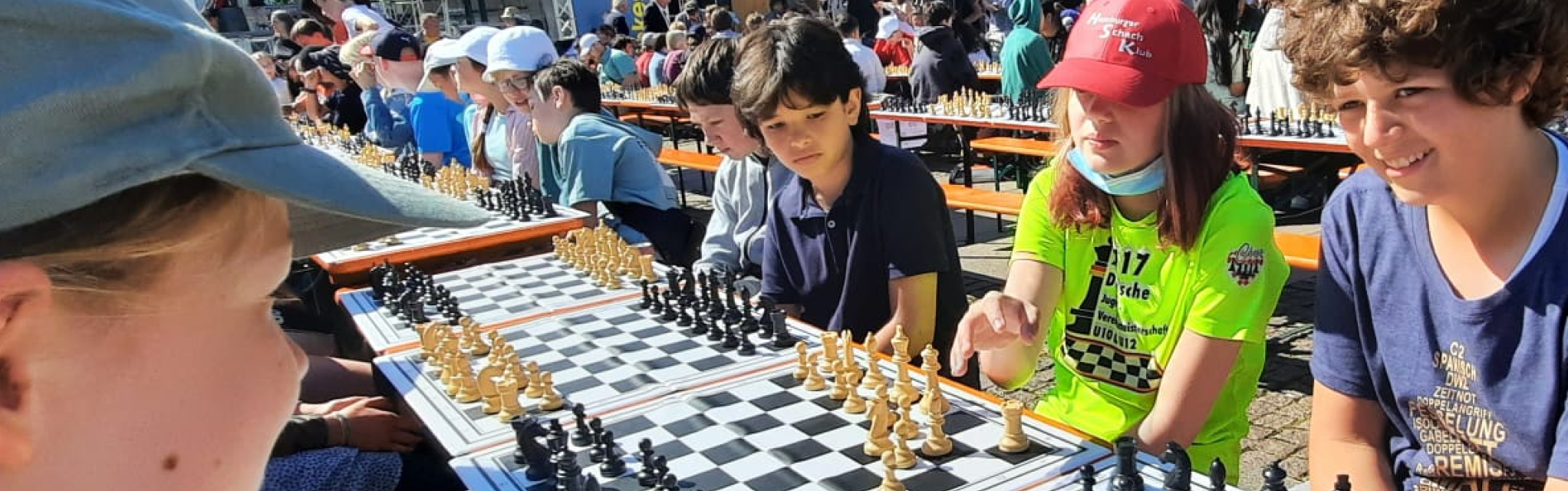 Schüler:innen sitzen vor dem Hamburger Rathaus und spielen Schach