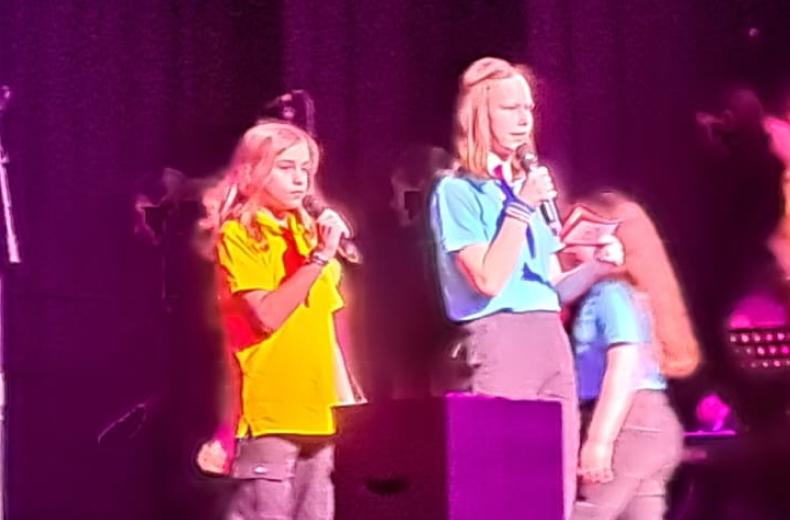 Zwei Schülerinnen singen mit Mikrofon
