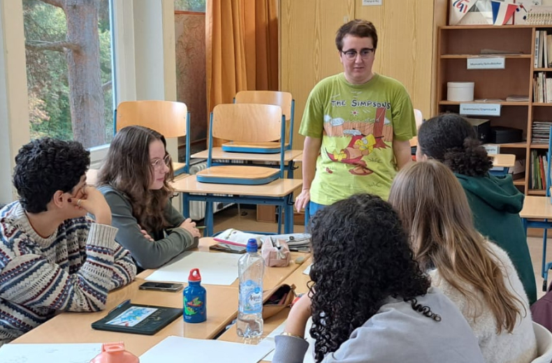 Schüler:innen mit Comickünstler Colin Athar bei einem Workshop